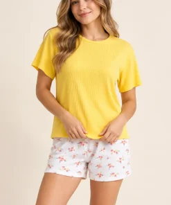 Modelo mujer con pijama de short estampado y camiseta amarilla en oferta de Paulina’s.