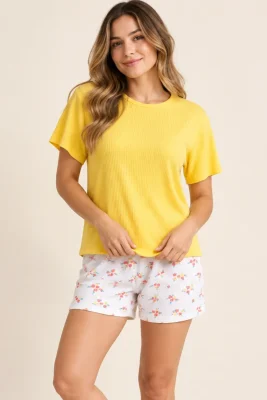 Modelo mujer con pijama de short estampado y camiseta amarilla en oferta de Paulina’s.